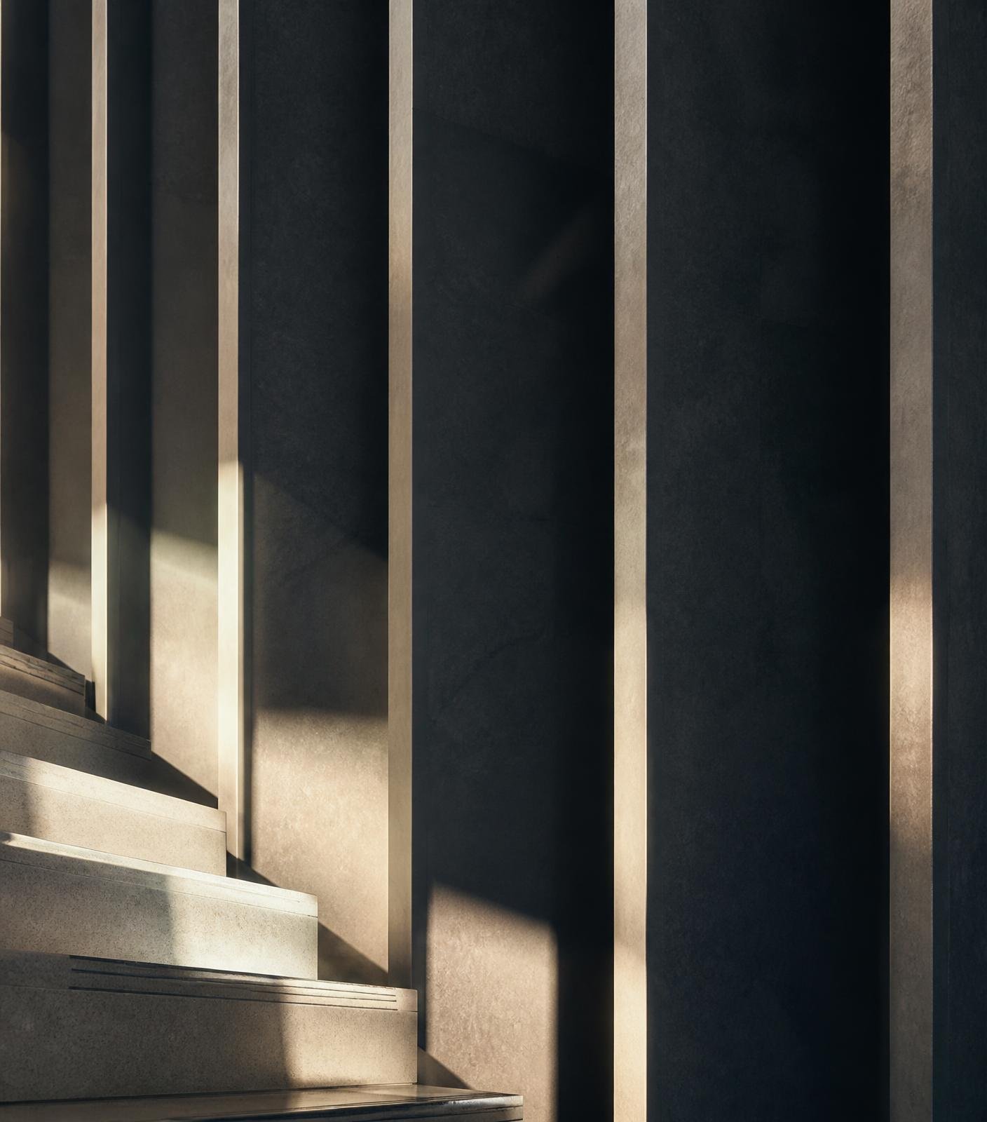 Raking daylight across a stone stair and vertical fins in a modern interior